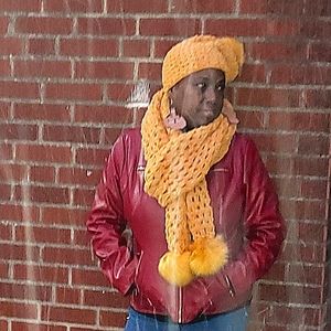 Gold open stitch scarf with faux fur pom. Matching hat.